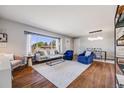 Bright living room features hardwood floors, large windows, and stylish decor for a comfortable space at 6924 S Albion St, Centennial, CO 80122