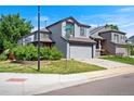 The two-story home features a well-manicured lawn, gray siding, and an attached two-car garage at 8791 Starwood Ln, Parker, CO 80134