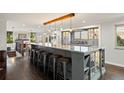Modern kitchen with a large island, barstool seating, and contemporary lighting fixtures at 3850 Hopi Dr, Sedalia, CO 80135