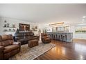 Open living space with hardwood floors, comfortable leather seating, and an expansive island with barstool seating at 3850 Hopi Dr, Sedalia, CO 80135