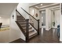 Elegant entryway showcasing hardwood floors, carpeted stairs with dark wood railings, and an open floor plan at 141 Back Nine Dr, Castle Pines, CO 80108