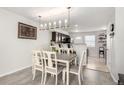 Dining room with a large table and unique light fixture next to the kitchen with barstool seating at 6450 Tennyson St # 1, Arvada, CO 80003