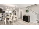 Open-concept dining area featuring a modern light fixture and decor adjacent to the home's stairway at 6450 Tennyson St # 1, Arvada, CO 80003