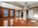 Spacious room with hardwood floors, white trim, natural light, and elegant lighting fixture at 581 N Flat Rock Cir, Aurora, CO 80018