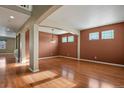 Open-concept living room featuring hardwood floors, arched columns, and natural light at 581 N Flat Rock Cir, Aurora, CO 80018