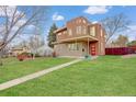 Modern home with a manicured lawn, unique architecture, and a vibrant red front door at 2624 S Race St, Denver, CO 80210