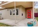 Charming covered front porch featuring a bright red door, neutral siding, and vibrant turquoise planters at 2624 S Race St, Denver, CO 80210