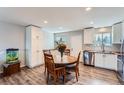 Kitchen with a dining table, stainless steel appliances, and white cabinets at 14798 E Temple Dr, Aurora, CO 80015