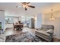 Spacious living room with neutral tones, ceiling fan, and cozy chair next to a staircase at 14798 E Temple Dr, Aurora, CO 80015