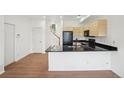 Stylish kitchen with dark countertops, modern cabinets, and a view of the staircase at 2253 Coronado Pkyn # D, Denver, CO 80229