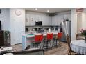 Open kitchen featuring gray cabinetry, a large island with seating, and stainless steel appliances at 5126 Buckwheat Rd, Brighton, CO 80640