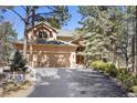 Attractive two-story home with a three-car garage and attractive mature trees surrounding the property at 20050 Lost Arrowhead Dr, Monument, CO 80132