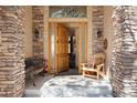 Inviting front porch featuring stone columns and an open door at 20050 Lost Arrowhead Dr, Monument, CO 80132