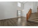 Bright living room featuring dark wood floors, a large window, and staircase at 134 Laramie Ct, Castle Rock, CO 80104