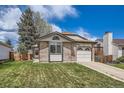 Charming single-Gathering home boasts a manicured lawn, brick accents, and an attached garage at 7661 Gray Way, Arvada, CO 80003