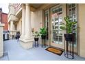 Elegant building entrance featuring stately columns and potted plants adorning the doorway and a grill on the deck at 1950 N Logan St # 102, Denver, CO 80203