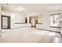 Bright living room with skylight, neutral walls, and an open layout at 8543 Redstone St, Highlands Ranch, CO 80126
