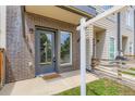 Close-up of a modern townhome's front door with brick facade, adjacent window, and a glimpse of the neighboring unit at 3520 W Conejos Pl # 11, Denver, CO 80204