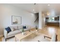 Bright living room with hardwood floors, modern furniture, and an open floor plan leading to the kitchen at 3520 W Conejos Pl # 11, Denver, CO 80204