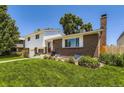 Charming two-story home with brick accents, a well-manicured lawn, and vibrant flower beds at 6348 S Independence St, Littleton, CO 80123