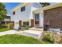 Charming two-story home showcasing a brick facade, white siding, and inviting front entrance with landscaped yard at 6348 S Independence St, Littleton, CO 80123