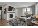 Cozy living room featuring a fireplace, plush sofa, and bright natural light from large windows at 4391 S Nepal St, Centennial, CO 80015