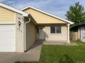 Inviting entryway with a white front door and well-manicured lawn at 894 S Krameria St, Denver, CO 80224