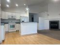 Open-concept kitchen flowing into the living room with a cozy fireplace and hardwood floors at 894 S Krameria St, Denver, CO 80224