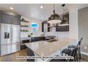 Modern kitchen with dark cabinetry, quartz countertops, and stainless steel appliances at 2732 W 68Th Ave, Denver, CO 80221