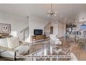 Open living space with hardwood floors, modern furniture, and a view of the kitchen at 2732 W 68Th Ave, Denver, CO 80221