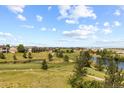 Scenic community view of a golf course, ponds and manicured lawns under a blue sky with scattered clouds at 7713 S Zante Ct, Aurora, CO 80016