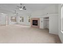 Bright living room with cozy fireplace, plush carpet, and large windows create a comfortable ambiance at 7713 S Zante Ct, Aurora, CO 80016