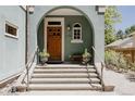 Inviting front entrance with a wooden door, arched entryway, and steps leading up to the home at 1260 Hudson St, Denver, CO 80220