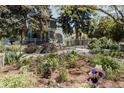 Beautifully landscaped front yard with lush garden beds, flowers, and a glimpse of the charming home at 1260 Hudson St, Denver, CO 80220