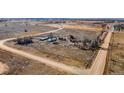A wide, exterior angle shows a expansive, dirt lot with several buildings at 14624 County Road 12, Fort Lupton, CO 80621