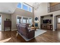 Comfortable living room with tall ceilings, large windows, a fireplace, and a stylish entertainment center at 696 Eveningsong Dr, Castle Rock, CO 80104