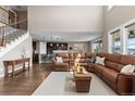 Open-concept living room with hardwood floors, a large sectional sofa, and seamless flow to the kitchen at 696 Eveningsong Dr, Castle Rock, CO 80104