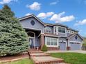 Charming two-story home featuring a well-manicured lawn, three-car garage, and brick-lined front steps at 6533 S Quemoy Way, Aurora, CO 80016