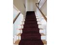 Carpeted staircase with a detailed runner, white risers and white and wood banisters at 1510 S Macon St, Aurora, CO 80012