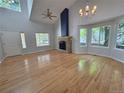 Spacious living room featuring hardwood floors, stone fireplace, and large bay window at 8772 S Carr Way, Littleton, CO 80128