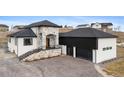 Stunning two-story home showcasing stone accents, a black roof, and an attached two-car garage at 10291 E 142Nd Ave, Brighton, CO 80602