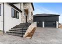 Stairs lead to the stunning front entrance, accentuated by stone and modern black railings at 10291 E 142Nd Ave, Brighton, CO 80602