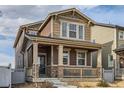 Inviting two-story house featuring a cozy front porch with stone accents and a well-maintained landscape at 18809 E 66Th Ave, Denver, CO 80249