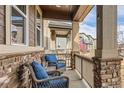 Relaxing front porch features comfortable seating, brick accents, and a view of the neighborhood at 18809 E 66Th Ave, Denver, CO 80249