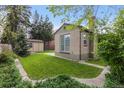 Charming home featuring a lush green backyard, brick exterior, and detached garage at 1090 E 3Rd Ave, Denver, CO 80218