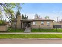 Charming brick home showcases a well-manicured lawn, secure fence, and classic architectural details at 1090 E 3Rd Ave, Denver, CO 80218