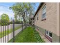 Home's exterior side with lush landscaping and secure perimeter fencing at 1090 E 3Rd Ave, Denver, CO 80218