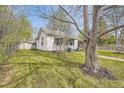 View of home's exterior with a well-maintained lawn, trees, and a brick pathway leading to the front entrance at 5510 S Windermere St, Littleton, CO 80120