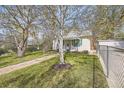 Home featuring well-kept lawn, trees, brick path leading to the entrance, and a chain-link fence at 5510 S Windermere St, Littleton, CO 80120