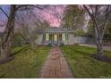 Charming home with well-manicured lawn, brick path, and cheerful green accents on the door and shutters at 5510 S Windermere St, Littleton, CO 80120